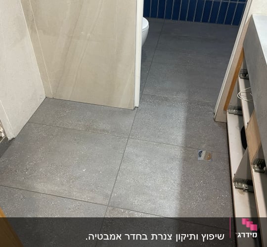 ריצוף חדש בחדר אמבטיה עם אריחים אפורים